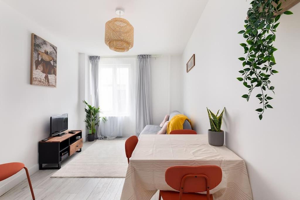 ein weißes Wohnzimmer mit Tisch und Stühlen in der Unterkunft Appart 2p cosy Paris & Disney in Gagny