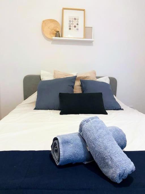 - un lit avec une serviette bleue dans l'établissement Le Petit Marius - Lyon 8, à Lyon