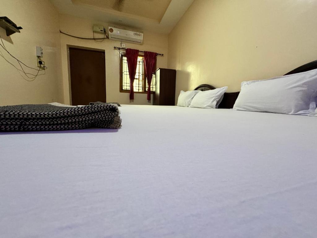 Postel nebo postele na pokoji v ubytování Sakthimurugan residency