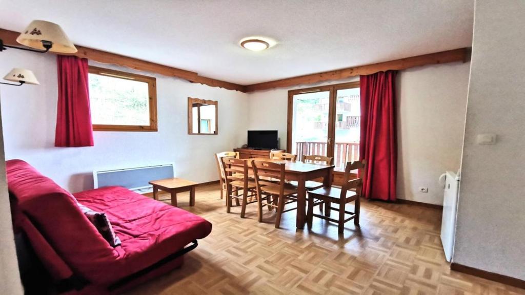un salon avec un canapé rouge et une table dans l'établissement Résidence Parc Aux Etoiles - GEB12 - APPARTEMENT 2 CHAMBRES ET TERRASSE MAE-7331, à Narreyroux