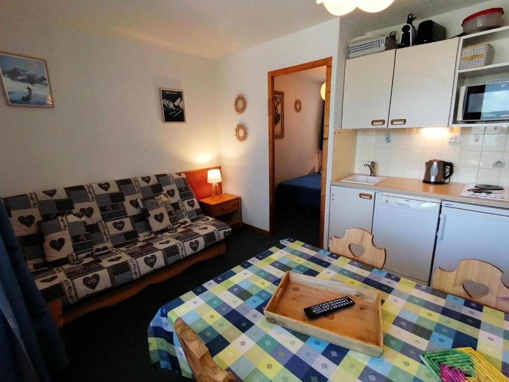 Cette chambre dispose d'un canapé, d'une table et d'une cuisine. dans l'établissement Résidence Le Chanteloup - 2 Pièces pour 4 Personnes 104, à Aime La Plagne