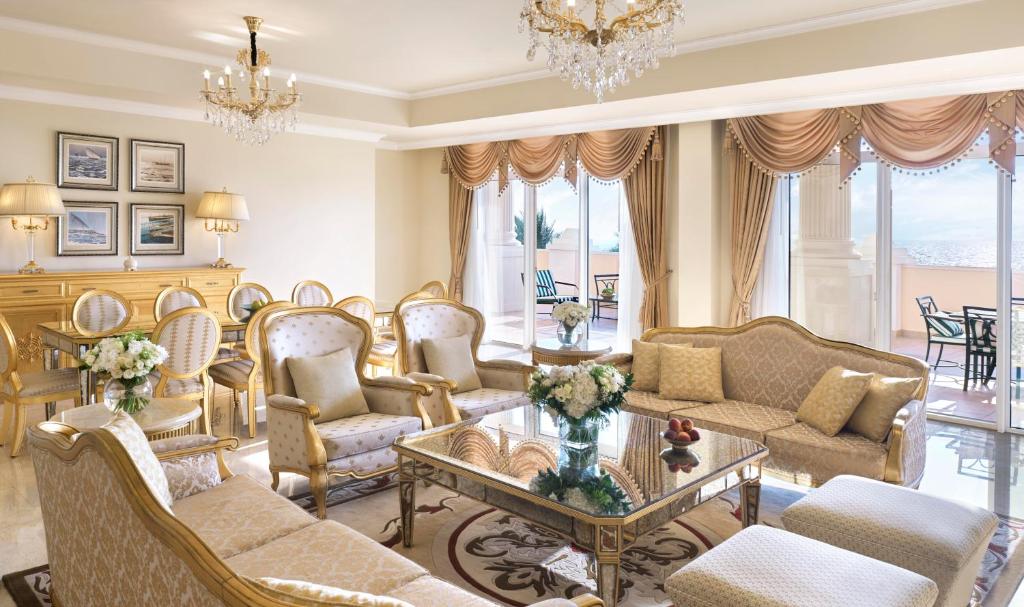 a living room with furniture and a chandelier at Kempinski Hotel Palm Jumeirah in Dubai