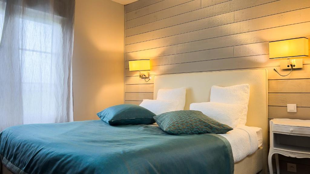 Postel nebo postele na pokoji v ubytování Logis hôtel Restaurant Le Faisan Dore