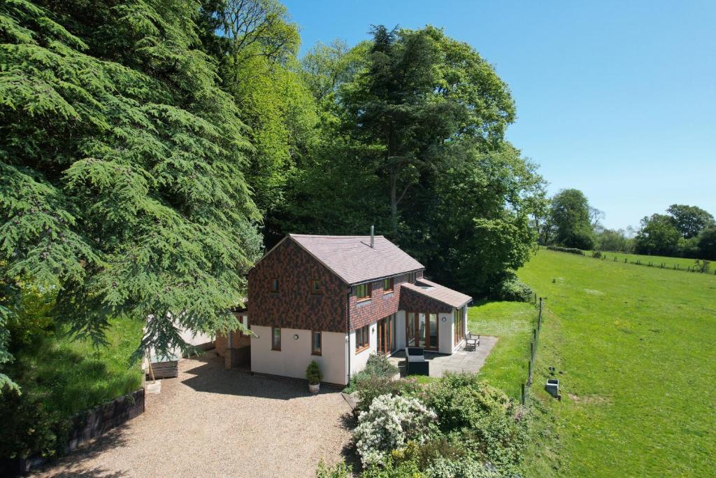 a small house in the middle of a field at Holly Cottage in Cranleigh