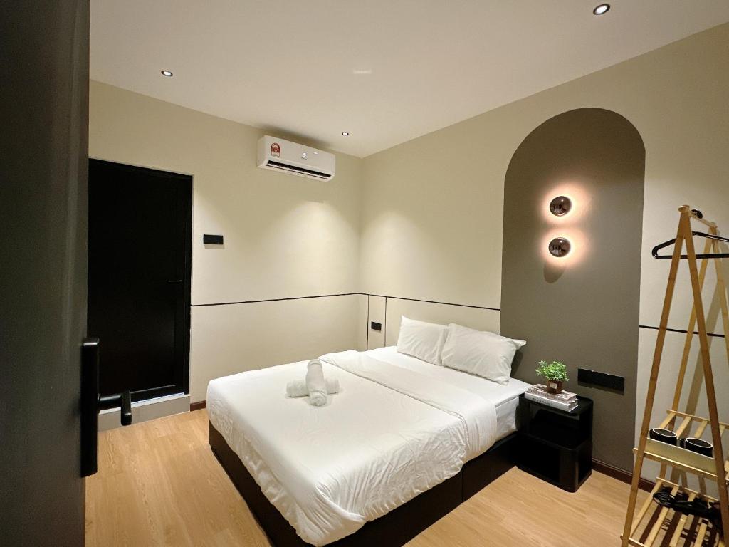 a bedroom with a bed with a white bedspread at The Jubilee Guest House in Ipoh