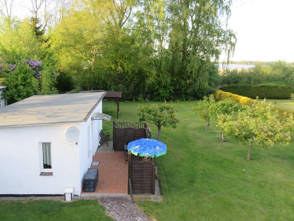 a small white building with a blue table in a yard at Bungalow Alms in Ribnitz-Damgarten