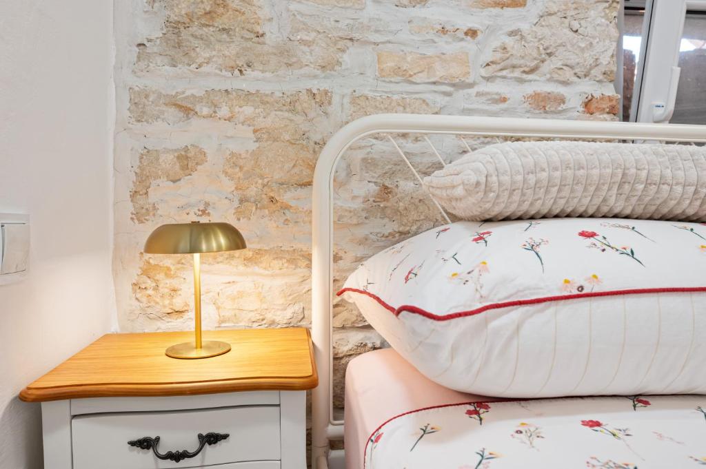sypialnia z łóżkiem i stołem z lampką w obiekcie Apartman tutto bene w Rovinj