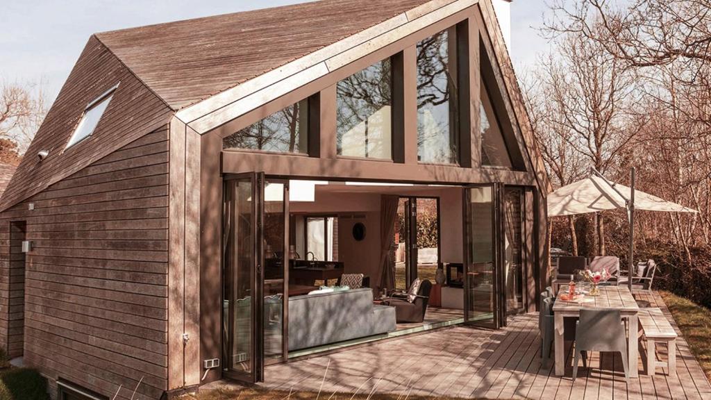 a house with glass doors and a patio at Dutchen Park Duynzoom in De Koog