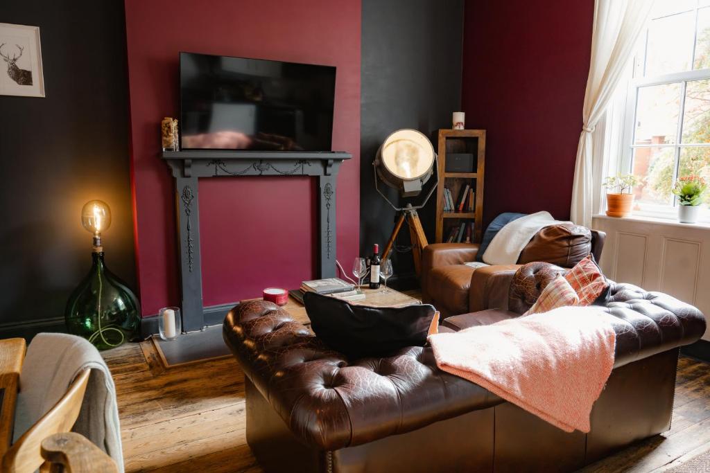sala de estar con sofá de cuero y chimenea en The Bolt Hole - Stratford Upon Avon - Central - Free Offstreet Parking, en Stratford-upon-Avon
