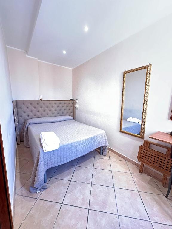 a bedroom with a bed and a mirror on the wall at Hotel Svizzera in Arma di Taggia