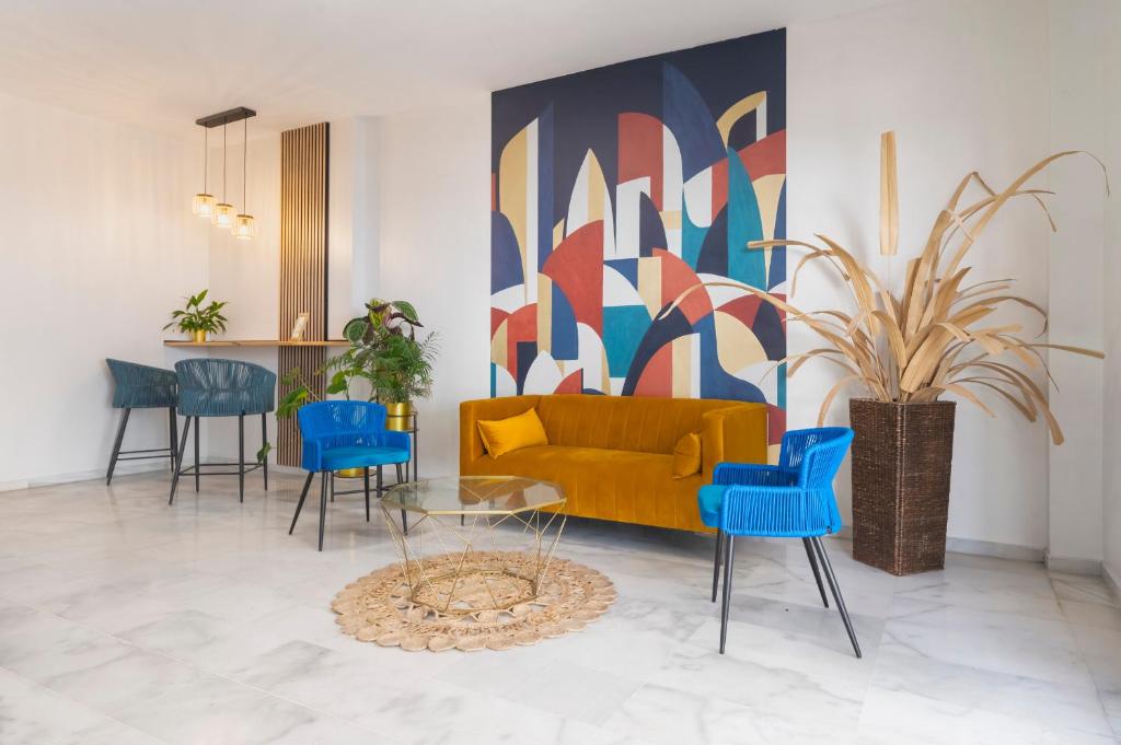a living room with a yellow couch and blue chairs at LuxSevilla Moderno Piscina Free Parking in Bormujos