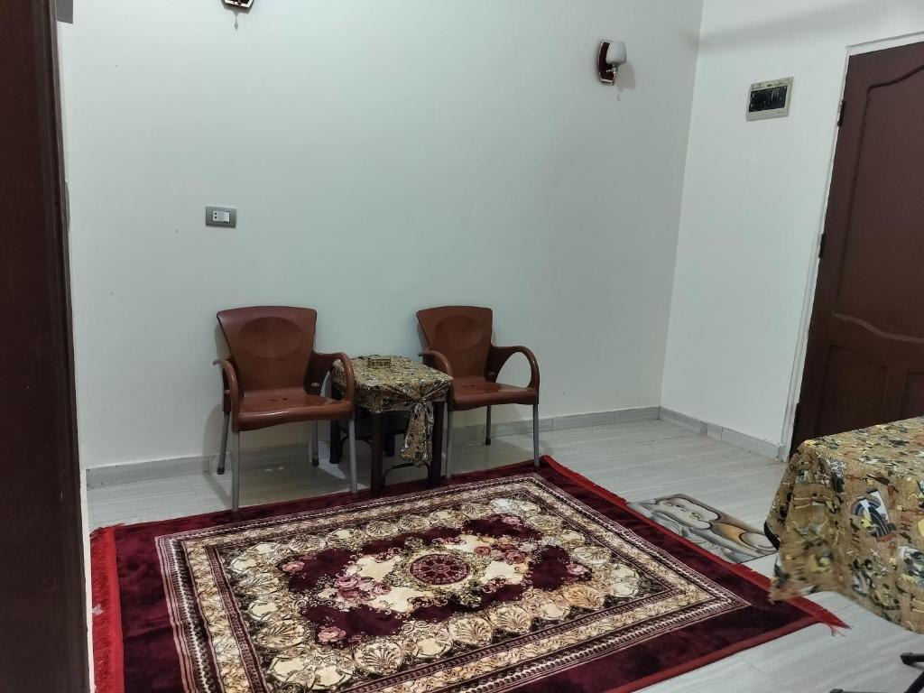 a living room with two chairs and a rug at Mooody nobin haws in Abu Simbel