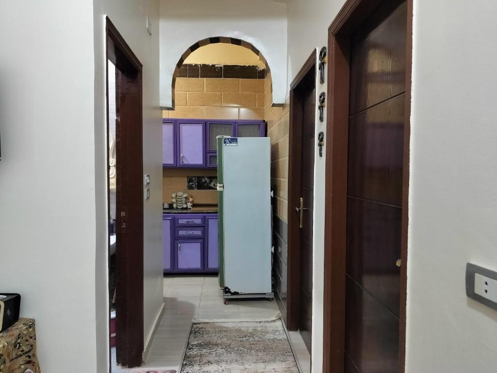 a kitchen with purple cabinets and a refrigerator at Mooody nobin haws in Abu Simbel