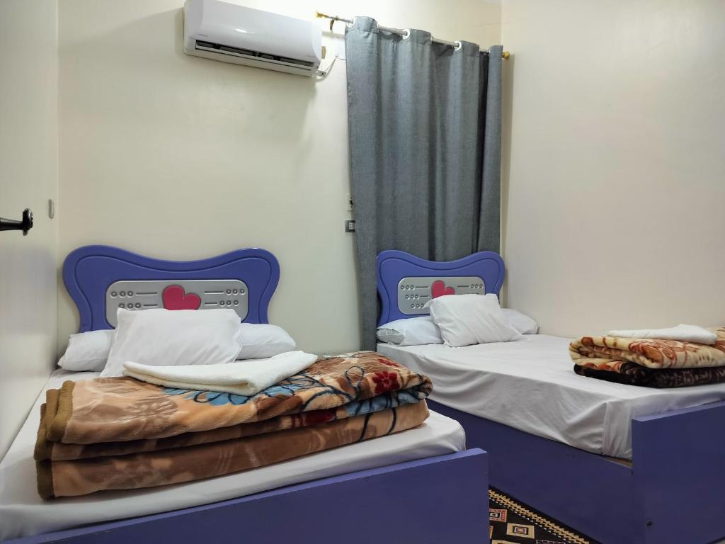 two beds sitting next to each other in a room at Mooody nobin haws in Abu Simbel
