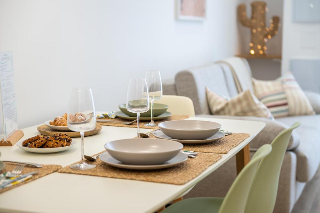 a table with plates of food and wine glasses at Main Lofts Valencia in Valencia