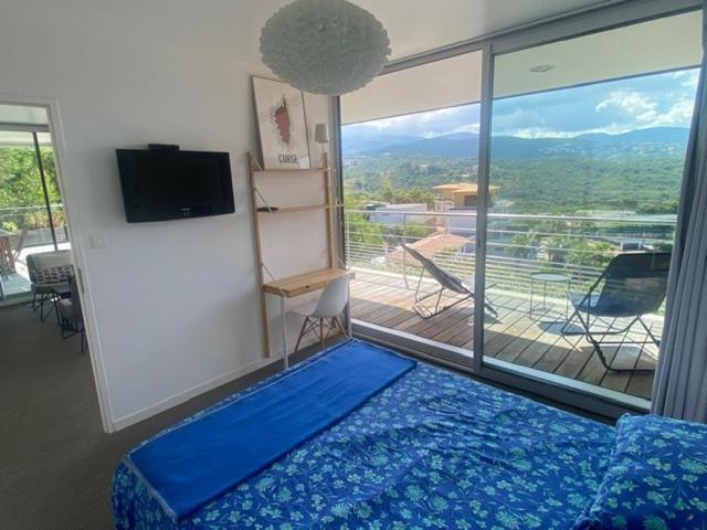 - une chambre avec un lit bleu et une grande fenêtre dans l'établissement Via Mare - Apt avec splendide vue, à Grosseto-Prugna