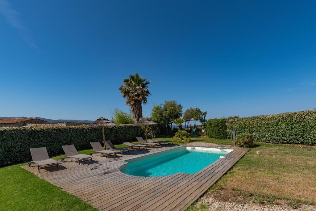 une arrière-cour avec une piscine et une terrasse en bois dans l'établissement Via Mare - Apt avec splendide vue, à Grosseto-Prugna