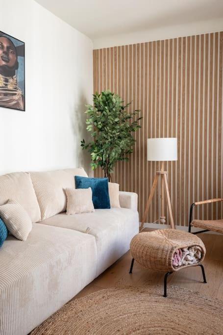 un salon avec un canapé blanc et une table dans l'établissement La Suite des Expositions, à Paris