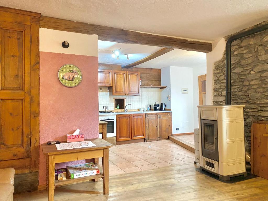 een keuken met houten kasten en een fornuis. bij La corte del meleto - appartamento in stile Valdostano in Saint-Pierre