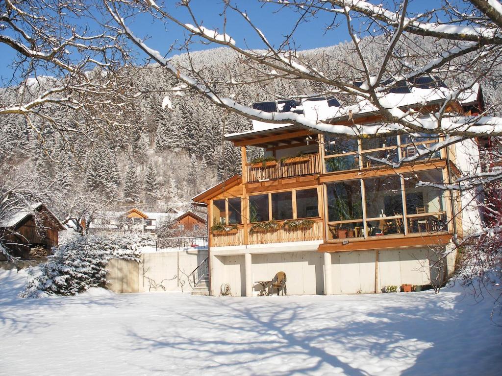ein Holzhaus mit Balkon im Schnee in der Unterkunft Zitas Ferienwohnung in Reisach