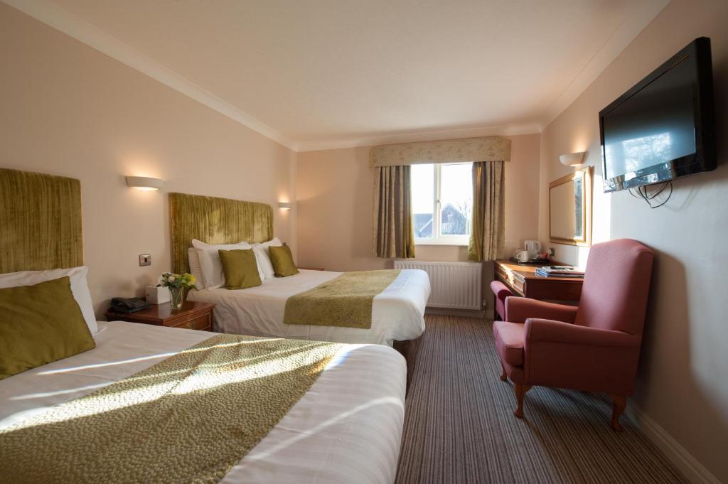 Habitación de hotel con 2 camas y TV de pantalla plana. en The Minster Hotel, en York