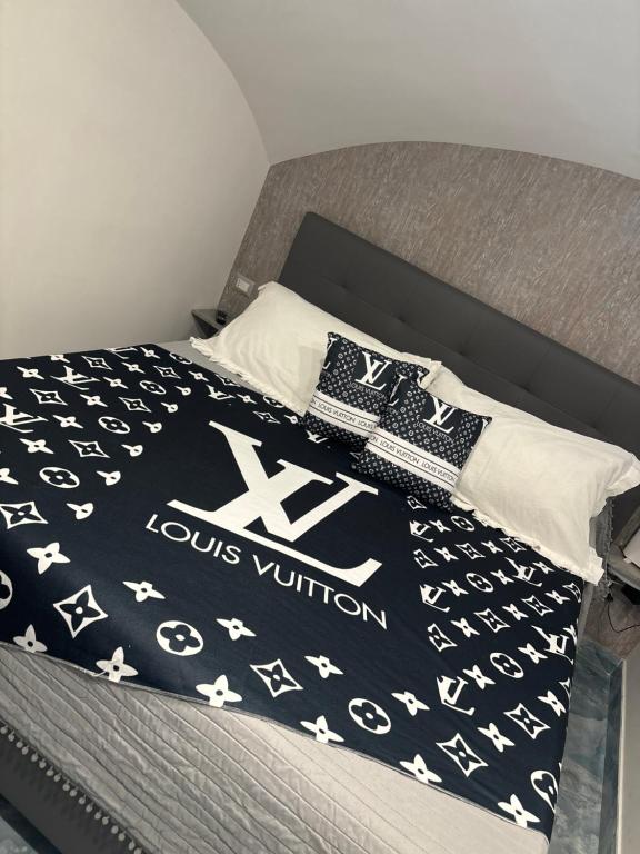 a bed with a black and white comforter and pillows at Aurora House 2 in Naples