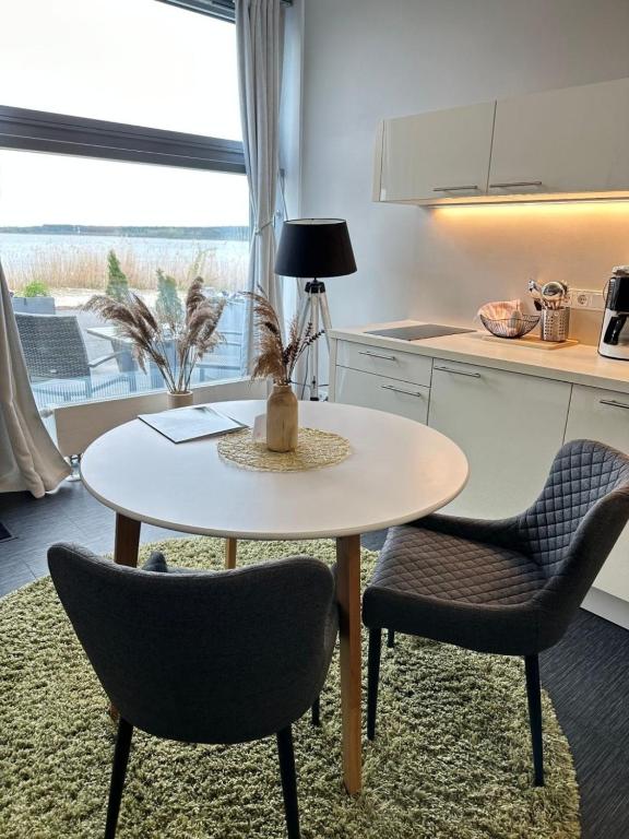 una piccola cucina con un tavolo e due sedie di Doppelzimmer im Strandhaus 2 Grundbelegung 2 Pers a Elsterheide