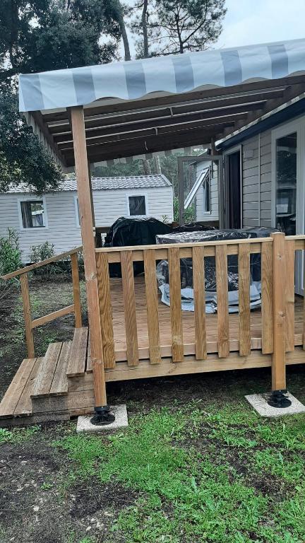 une terrasse en bois recouverte sur une maison dans l'établissement MH 229 C0C00NING 2ch et 2sdb à proximité des activités dans camping 4 étoiles, à Saint-Julien-en-Born