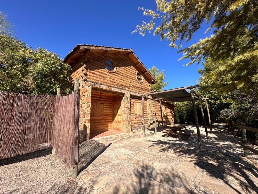 a wooden cabin with a fence in front of it at CASA DE MADERA ZUMACAR VI in Cazorla