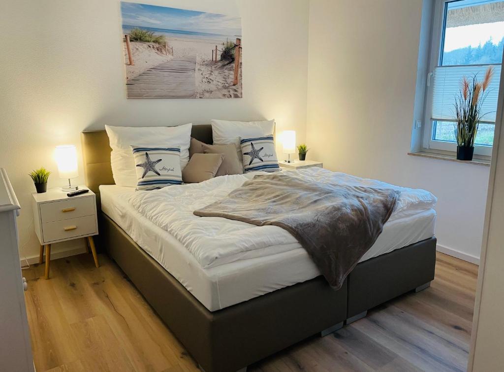 a bedroom with a large bed with two night stands at Reetdach-Ferienhaus "ANNI" mit direktem Meerblick, Sauna und Kamin in Pepelow