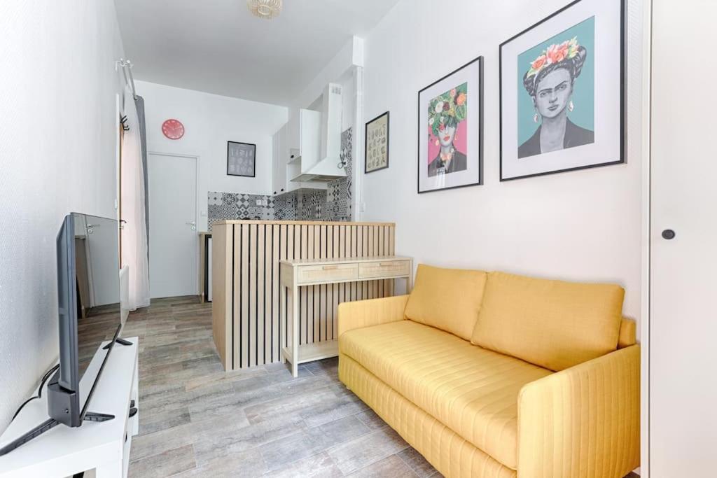 un salon avec un canapé jaune et une télévision dans l'établissement République Canal St Martin Charming Apartment, à Paris