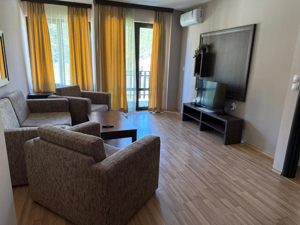 a living room with two couches and a flat screen tv at Мия4 Спа хотел Свети Спас in Velingrad