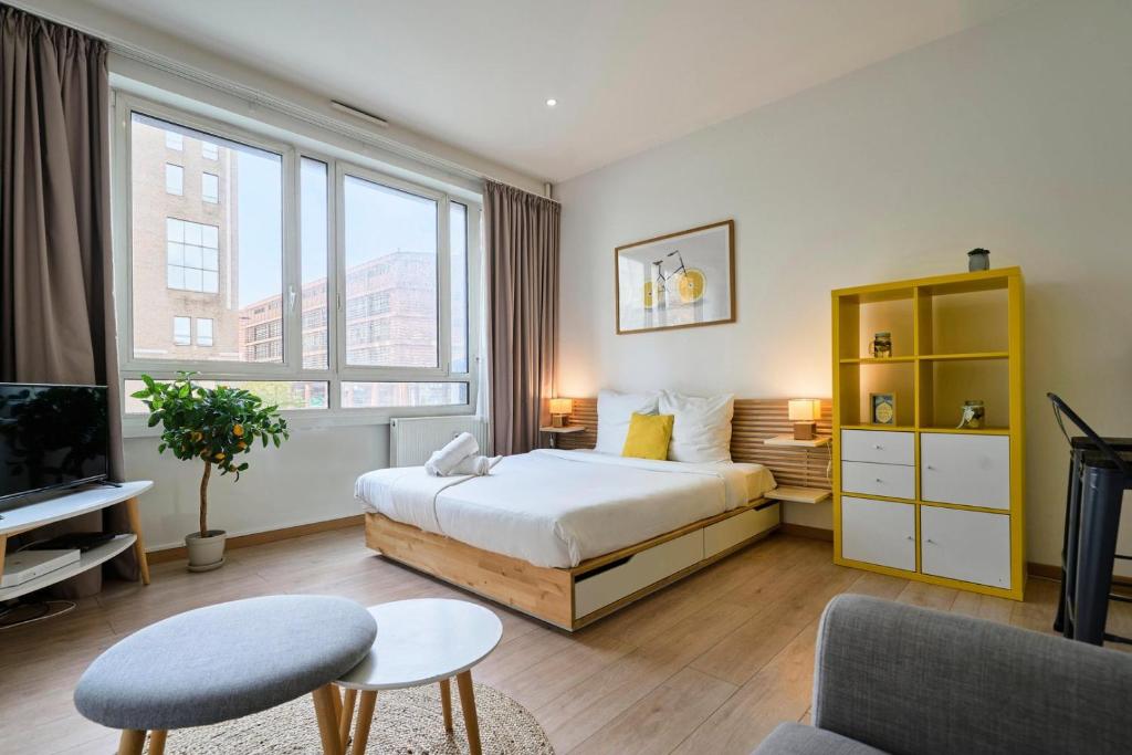 une chambre d'hôtel avec un lit et une télévision dans l'établissement Lille gares studio avec parking sécurisé, à Lille