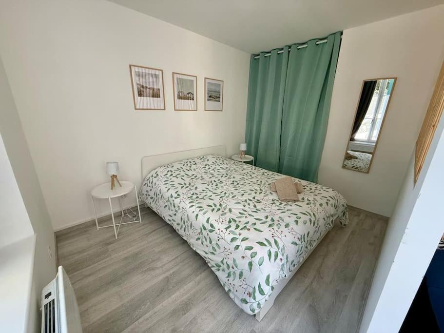 une chambre avec un lit et une table dedans dans l'établissement Le Nid Douillet - Appart 2-4P vieux Boulogne, à Boulogne-sur-Mer