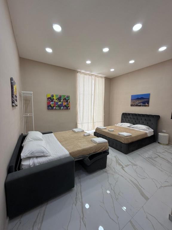 two beds in a room with marble floors at Valentino caracciolo 105 in Naples