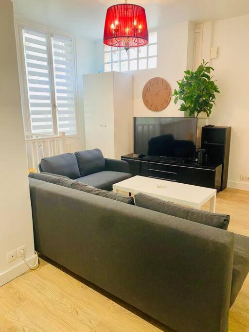 un salon avec un canapé et une table dans l'établissement Maisonnette au calme proche T2, à La Garenne-Colombes