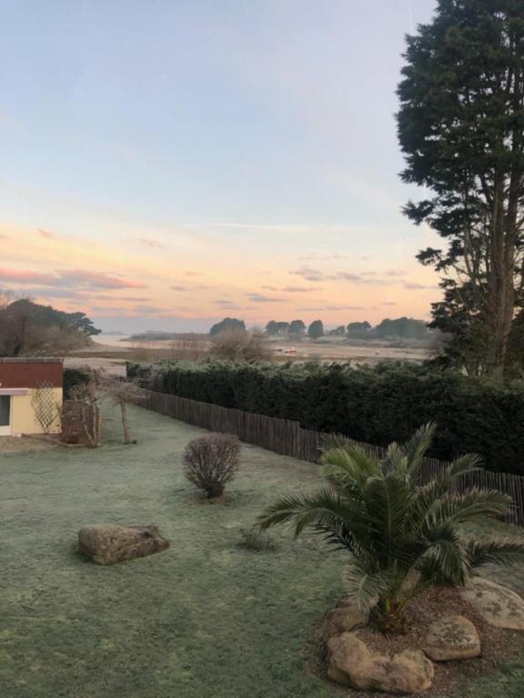 un jardin avec des rochers, une clôture et une cour dans l'établissement Kerlavost, à Trégastel