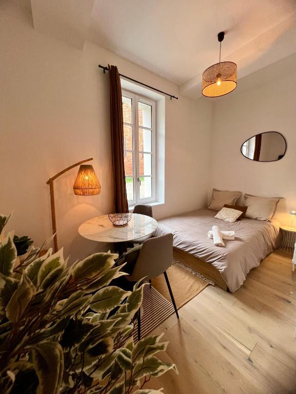 un salon avec un lit et une table dans l'établissement L'intime Saint Pierre - Paisible - Centre ville, à Toulouse