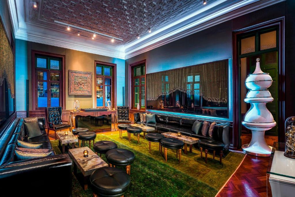 A richly styled lounge with a piano, low seating, and dramatic lighting.