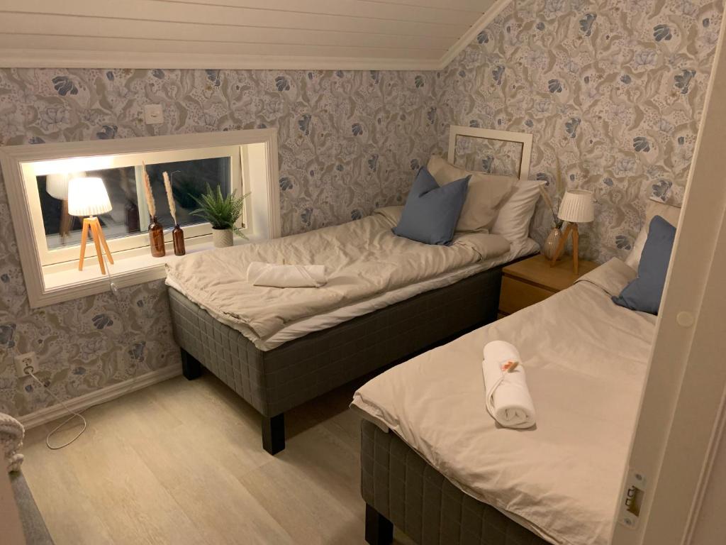 a bedroom with two beds and a mirror and a window at Bellmangården in Matfors