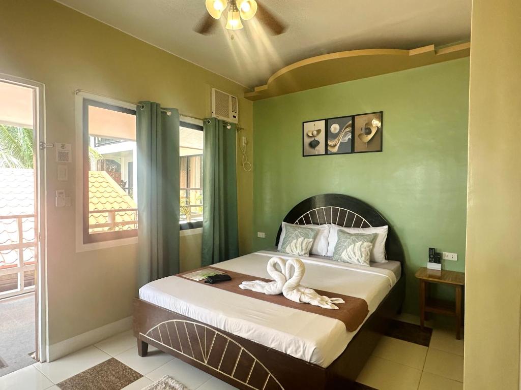 a bedroom with a bed with two swans on it at Panari Lodge El Nido in El Nido