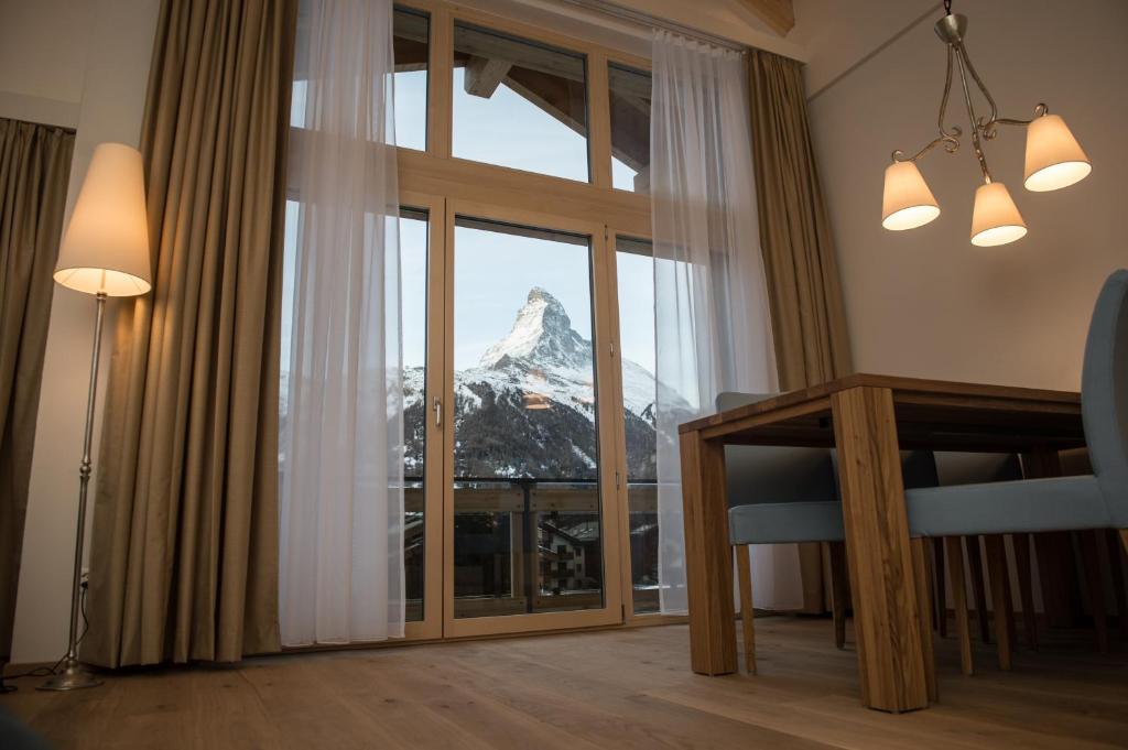 a room with a view of a mountain through a window at Panorama Ski Lodge in Zermatt