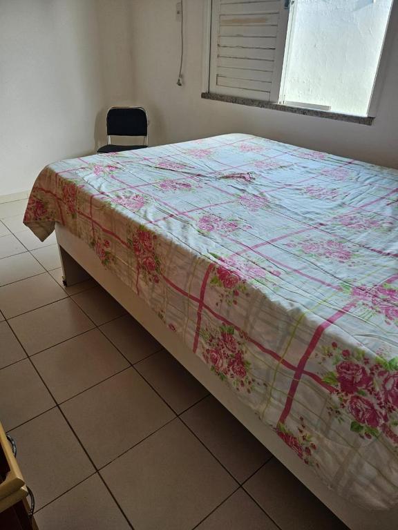 a bed with a quilt on it in a bedroom at Casa de Paraia em Aracaju in Aracaju