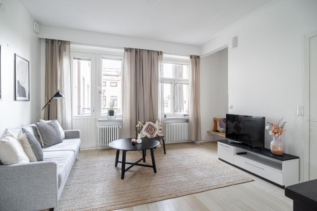a living room with a couch and a tv at "PENTHOUSE" - Renovated 1BR Apt with Sauna & 60m2 Private Terrace in Tampere