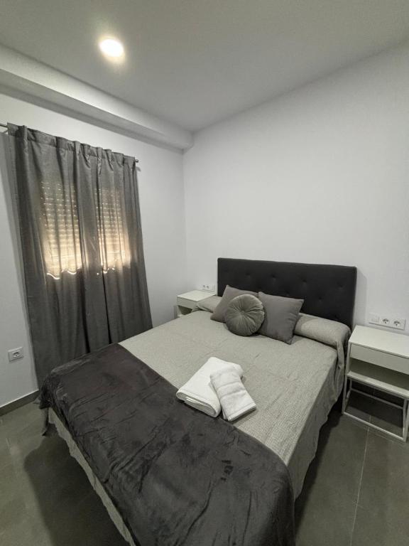 Un dormitorio con una cama grande con dos toallas encima. en Lacana, en Chiclana de la Frontera