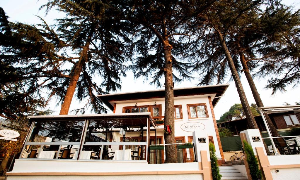 uma casa com árvores em frente em Nizam Butik Otel Büyükada em Buyukada