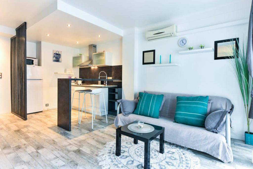 un salon avec un canapé et une table dans l'établissement LE ROYAL Studio adorable avec terrasse, parfait pour les couples et à deux pas de la Croisette, à Cannes