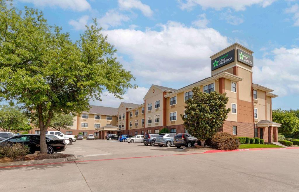 a hotel with cars parked in a parking lot at Extended Stay America Select Suites - Dallas - Lewisville in Lewisville