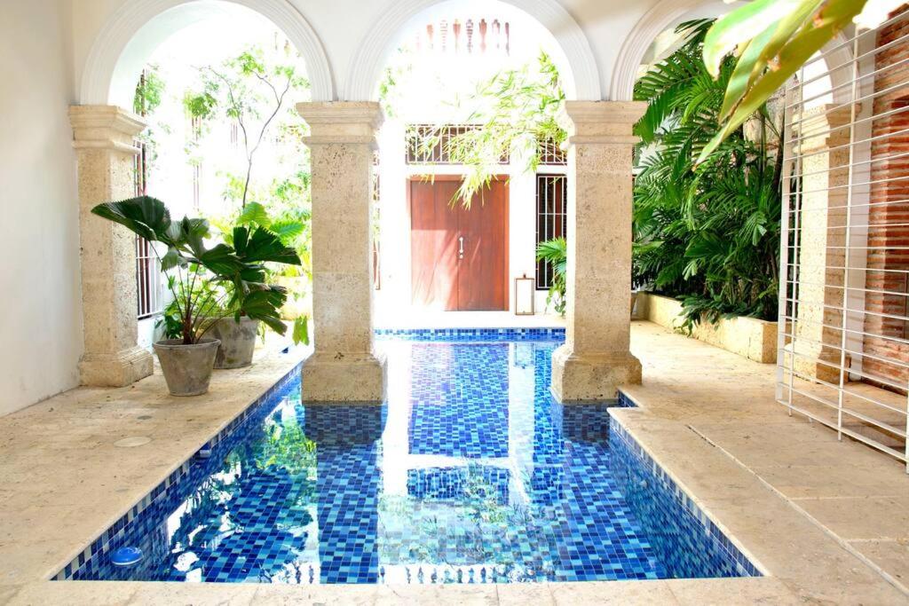 une piscine au milieu d'une cour avec une maison dans l'établissement Charming 1BR apartment in the Heart of Cartagena's Old City, à Carthagène des Indes