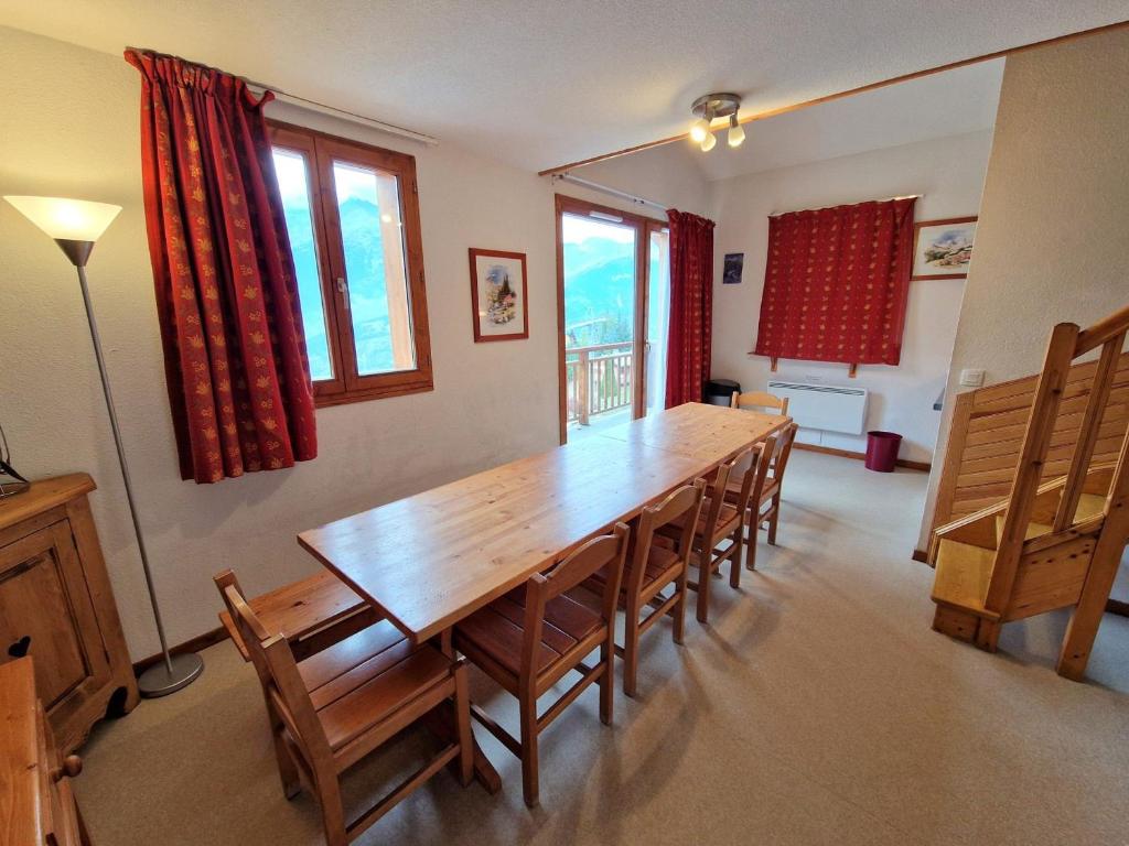 une salle à manger avec une table et des chaises en bois dans l'établissement Joli duplex spacieux 10/12 personnes - FR-1-265-174, à Valfréjus